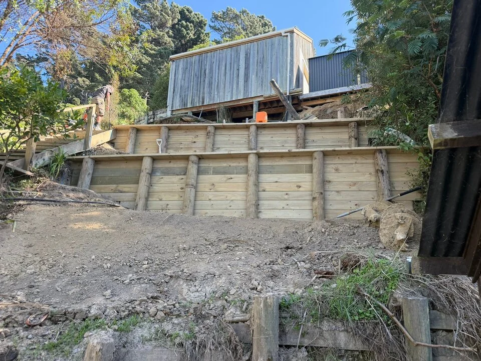 Timber retaining wall replacement on a sloping property
