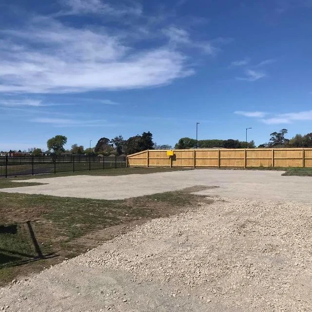 Compacted building pad beside a timber boundary fence